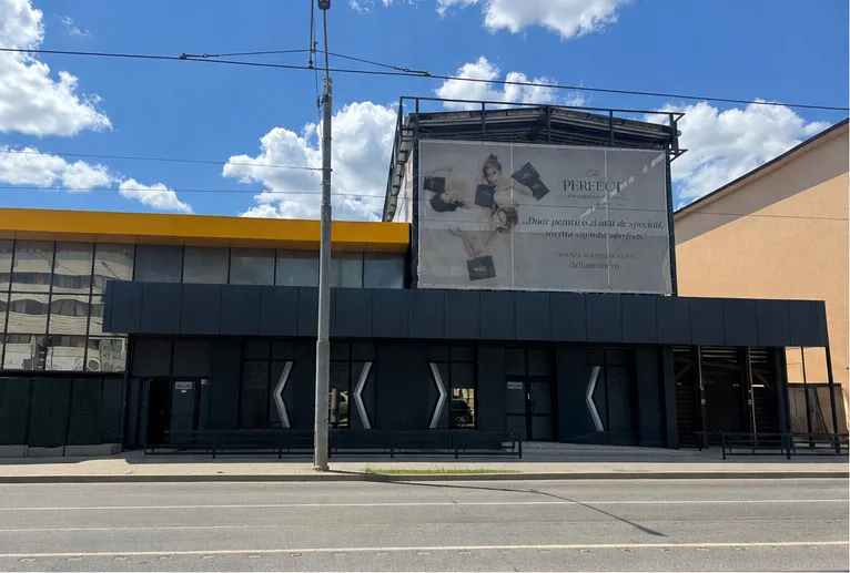 Fațada principală a clădirii, cu banda galbenă și panourile Alucobond gri antracit, văzută frontal de pe bulevard